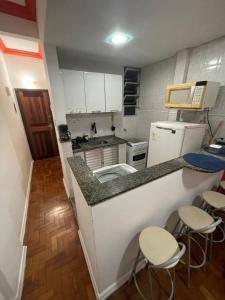 a small kitchen with a counter and stools in it at Apartamento na Zona Sul Carioca in Rio de Janeiro