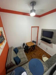 Il comprend un salon doté d'un canapé et d'une télévision à écran plat. dans l'établissement Apartamento na Zona Sul Carioca, à Rio de Janeiro