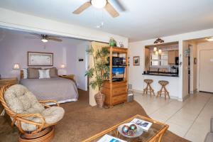 a bedroom with a bed and a living room at Suite Maui Paradise Condo in Wailuku