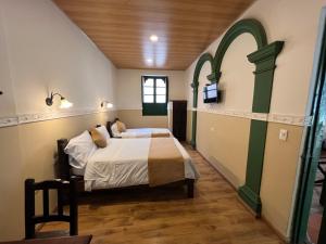 a bedroom with a bed and a tv on a wall at Hotel La Gran Casona in Tunja