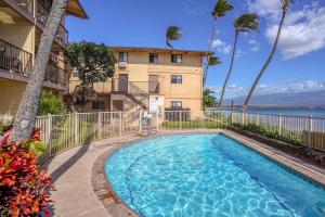 a swimming pool in front of a building at Suite Maui Paradise Condo in Wailuku