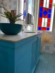 a blue cabinet with a sink and a potted plant on it at Hotel Cidade Imperial in Petrópolis