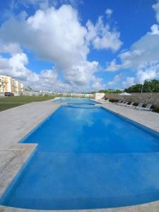 uma grande piscina com água azul em Pool Breeze 202 em Punta Cana