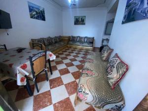 een woonkamer met een bank en een geruite vloer bij Complexe Jardins andalouse in Tanger