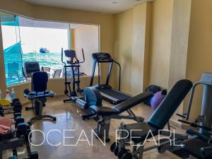 einen Fitnessraum mit Laufbändern und Heimtrainern in einem Zimmer in der Unterkunft The Ocean Pearl Beachfront Infinity Pool Gym BBQ in Manzanillo