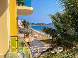 einen Balkon mit Blick auf den Strand und das Meer in der Unterkunft The Ocean Pearl Beachfront Infinity Pool Gym BBQ in Manzanillo