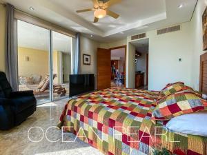 ein Schlafzimmer mit Bett und Deckenventilator in der Unterkunft The Ocean Pearl Beachfront Infinity Pool Gym BBQ in Manzanillo + 58 Fotos