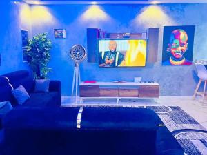 a blue living room with a couch and a tv at appartement meublé avec spa jacuzzi in Mbour