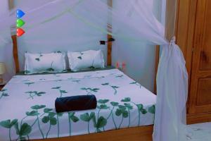 ein Schlafzimmer mit einem weißen Bett mit grünen Pflanzen darauf in der Unterkunft appartement meublé avec spa jacuzzi in M'bour
