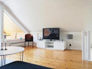 a living room with a flat screen tv on a white cabinet at Holiday home YXLAN in Yxlö