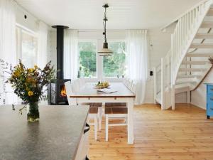 a kitchen with a white table and a dining room at Holiday home YXLAN in Yxlö