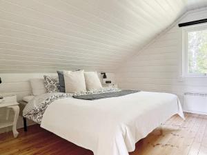 a bedroom with a white bed and a window at Holiday home YXLAN in Yxlö