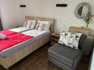 a bed with a red blanket and a chair in a room at Vila Vista Magica Radozda in Struga