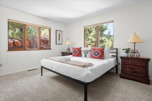 a bedroom with a large bed and two windows at Oak Ridge at Palisades in Sedona