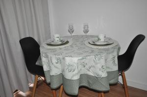 a table with two wine glasses and a table cloth at Studio no centro in Poços de Caldas