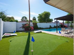 a backyard with a putting green and a pool at Stay Golden in Tempe