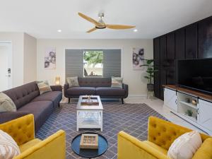 a living room with couches and a flat screen tv at Stay Golden in Tempe