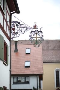 ein Gebäude mit einem roten Dach mit einem Kreuz darauf in der Unterkunft Gasthaus Hotel zum Kreuz in Stetten am Kalten Markt