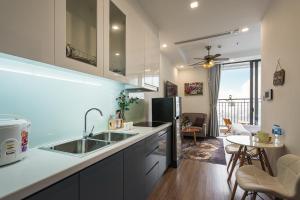 a kitchen with a sink and a living room at Rosee House -Luxury apartment in vinhomes Greenbay in Hanoi