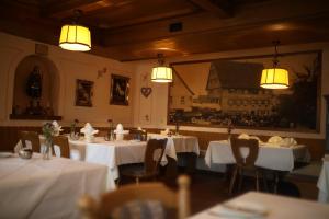 a restaurant with white tables and chairs and lights at Gasthaus Hotel zum Kreuz in Stetten am Kalten Markt