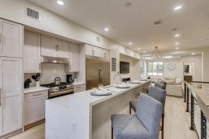 a kitchen with white cabinets and a large island with chairs at Parkway Paradise in Scottsdale