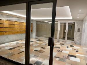 um átrio com portas de vidro e piso em azulejo em Evian appartement confort Vue lac et parking privé em Évian-les-Bains