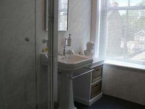 y baño blanco con lavabo y ducha. en 16 Franklin Bijou Boutique, en Harrogate