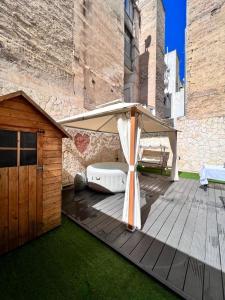 a wooden deck with an umbrella next to a building at Lady Luxury Apartment in Bari