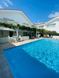 una grande piscina blu di fronte a una casa di Isabella Boutique Hotel a San Pedro Sula