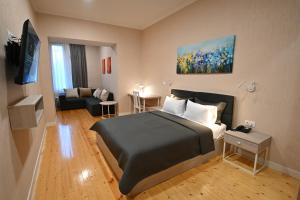 1 dormitorio con 1 cama y sala de estar en Hotel Well Inn, en Tiflis