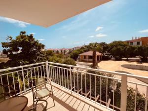 a balcony with a chair and a view of a park at Apartamento T2 equipado Vila Verde in Santa Maria