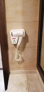 een witte telefoon hangt aan een muur bij Seven Days Hotel in Irbid