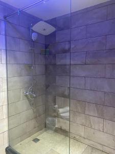 baño con ducha y puerta de cristal en Seven Days Hotel, en Irbid