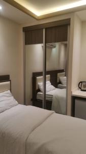 a bedroom with two beds and a large mirror at Seven Days Hotel in Irbid