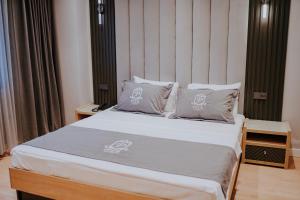 1 dormitorio con 1 cama con sábanas y almohadas blancas en Pier Hotel, en Estambul