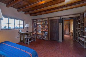 een slaapkamer met een bed, een bureau en boekenplanken bij Canyon Getaway- Courtyard, Canyon Rd & Plaza, 1BR in Santa Fe