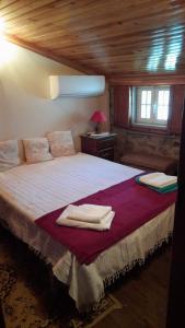 a bedroom with a large bed with towels on it at A Casinha do Beco in Gouveia