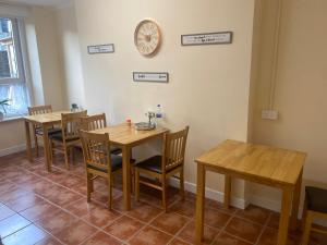 un comedor con mesas y sillas y un reloj en la pared en Waterford Hostels Ltd, en Waterford