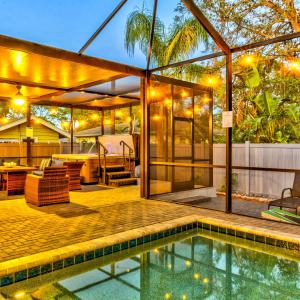 an outdoor patio with a swimming pool and a house at Luxury Home in Downtown Sarasota, HTD POOL/Hot tub in Sarasota
