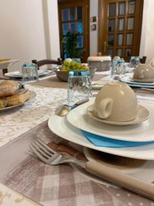 a table with plates and utensils on a table at Locanda 130 in Fonni