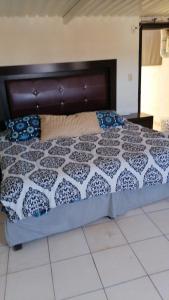 Casa Lopez Camarena Arandas Jalisco في Arandas: سرير لحاف من اللون الأزرق والأبيض في الغرفة