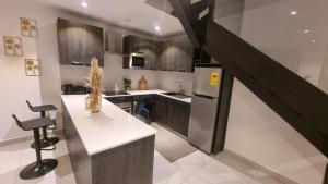 a kitchen with a staircase leading up to a kitchenasteryasteryasteryasteryasteryastery at The Lennox Suites by Cozy in Accra