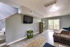 a living room with a couch and a tv on a wall at Waterfront Burgaw Vacation Rental with Private Yard! in Burgaw