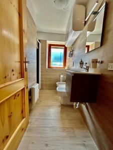 a bathroom with a sink and a toilet and a window at Nido Del Cervino - Ingresso Indipendente in Valtournenche