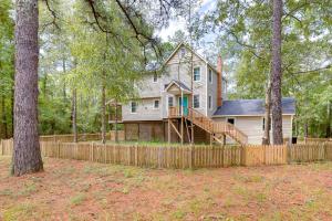 a house with a wooden fence in front of a yard at Waterfront Burgaw Vacation Rental with Private Yard! in Burgaw