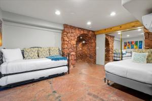um quarto com duas camas e uma parede de pedra em Crimson Sky Chalet em Sedona
