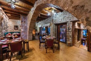 a restaurant with tables and chairs and a stone wall at Vilaeti Dimitra in Agios Konstantinos