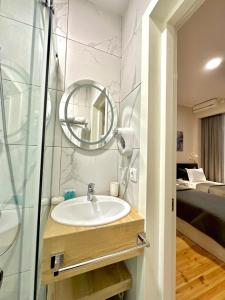 La salle de bains est pourvue d'un lavabo et d'un miroir. dans l'établissement Hotel Well Inn, à Tbilissi