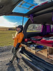 una mujer está de pie en la parte trasera de una furgoneta en Isla Yu Patagonia en Puerto Natales