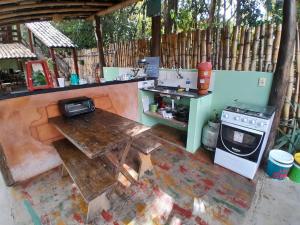 an outdoor kitchen with a table and a stove at Pousada Alecrim in Serra do Cipo